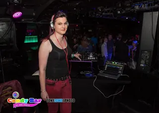 DJ Selina Style at the booth, crowd on the floor behind