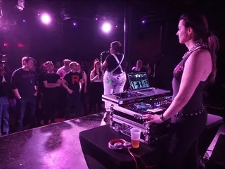 DJ Selina Style at the decks on stage, the crowd in front