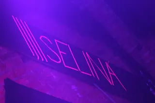 SELINA neon sign over the booth