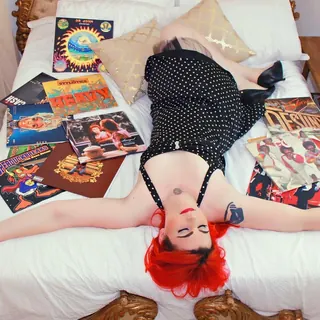 DJ Selina Style lying across a bed of records