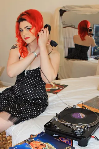 DJ Selina Style in headphones beside a turntable