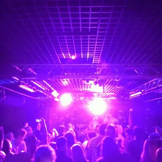 Packed Candy Bar dance floor under purple lights